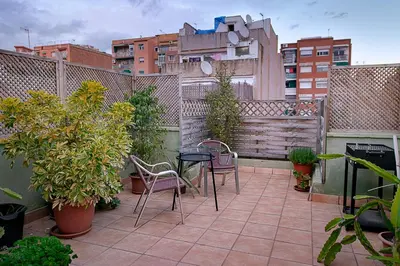a patio with two chairs and a table on a balcony at Kamelly in Badalona