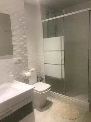 a bathroom with a toilet and a glass shower at Kamelly in Badalona