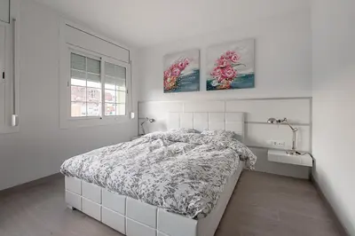 a bedroom with a bed and two pictures on the wall at Kamelly in Badalona
