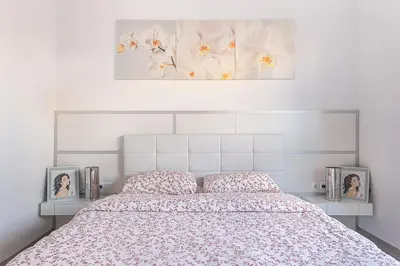 a bedroom with a bed with two pictures on it at Kamelly in Badalona