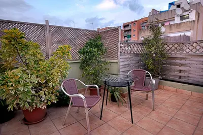 a patio with two chairs and a table on a balcony at Kamelly in Badalona