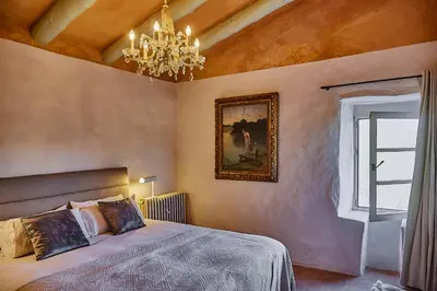 a bedroom with a bed and a chandelier at Manor House at Masia Nur Sitges, Adults only in Canyelles