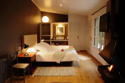 a bedroom with a large white bed and a television at Can Barrina in Montseny