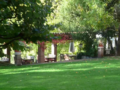 a garden with tables and chairs under a pergola at Can Barrina in Montseny