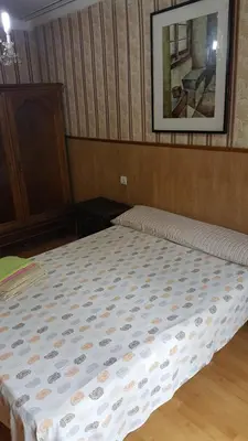 a bed in a bedroom with a picture on the wall at Pensión Villanueva in Barcelona
