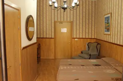 a room with a bed and a chair and a mirror at Pensión Villanueva in Barcelona