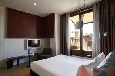 a hotel room with a bed and a desk and a window at Mercer Casa Torner i Güell in Vilafranca del Penedès