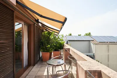 a balcony with a table and chairs and solar panels at Mercer Casa Torner i Güell in Vilafranca del Penedès