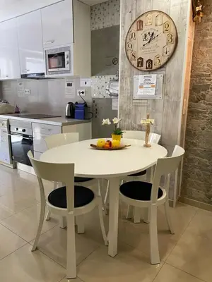 a white table and chairs in a kitchen with a clock at BADAROSA House10min to BARCELONA City&NearTo BEACH in Badalona