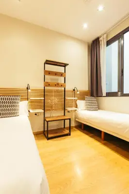 a room with two beds and a table at Casa Felipa Plaza España in Barcelona
