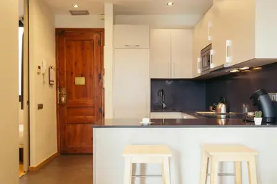 a kitchen with a counter and two stools in it at Casa Felipa Plaza España in Barcelona