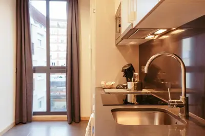 a kitchen with a sink and a large window at Casa Felipa Plaza España in Barcelona