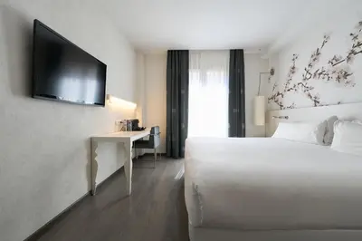 a hotel room with a bed and a flat screen tv at Catalonia La Boquería in Barcelona
