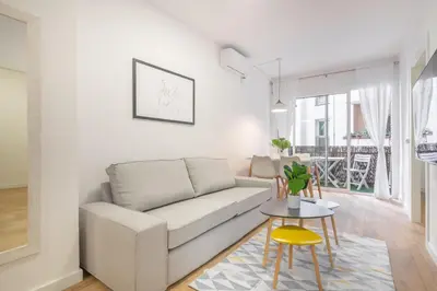 a living room with a couch and a glass table at The White Flats Les Corts in Barcelona