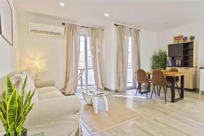 a dining room and living room with a table and chairs at The White Flats Les Corts in Barcelona