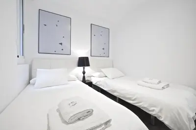 a white dining room with a white table and chairs at The White Flats Les Corts in Barcelona