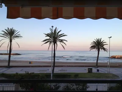 a bedroom with a bed with a view of the ocean at Apartamento Primera Linea de Mar, Cunit in Cunit