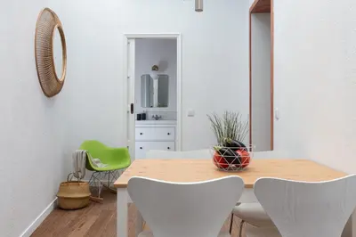 a dining room with a wooden table and chairs at Casa Cosi - Eixample 1 in Barcelona
