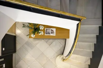 a staircase in a house with a gold rail at Casa Cosi - Eixample 1 in Barcelona