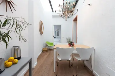 a dining room with a table and white chairs at Casa Cosi - Eixample 1 in Barcelona