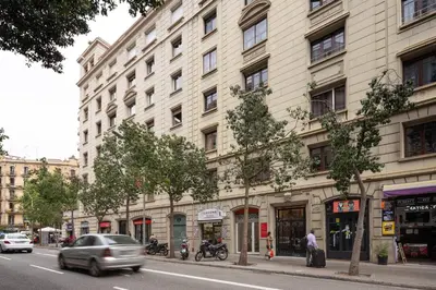 a large building on a city street with cars at Casa Cosi - Eixample 1 in Barcelona