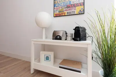 a white console table with a clock on it at Casa Cosi - Eixample 2 in Barcelona