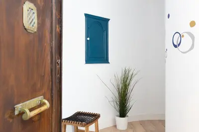 a door with a stool next to a plant at Casa Cosi - Eixample 2 in Barcelona
