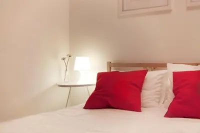 a bed with two red pillows and a table at Spot Smart Nomad in Barcelona
