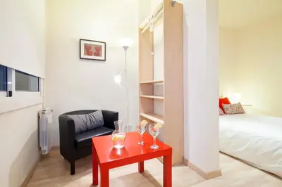 a living room with a red table and a bed at Spot Smart Nomad in Barcelona
