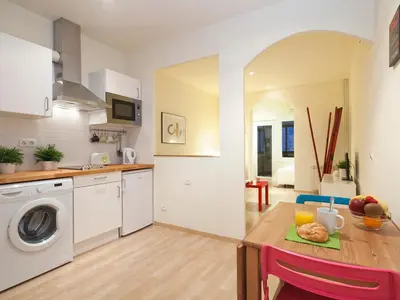 a kitchen with a table and a washing machine at Spot Smart Nomad in Barcelona
