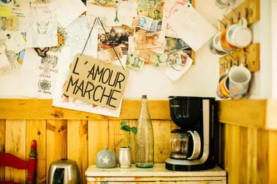 a counter with a coffee maker and a sign on a wall at Rocket Hostels Gracia in Barcelona
