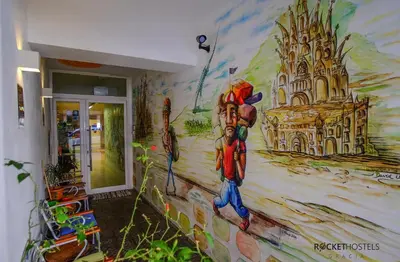 a mural on the wall of a room with a painting at Rocket Hostels Gracia in Barcelona