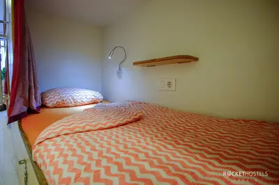 a small bedroom with a bed and a window at Rocket Hostels Gracia in Barcelona
