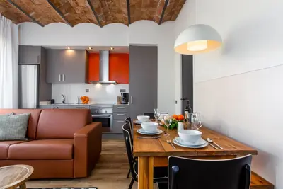 a dining room and kitchen with a table and a couch at Ola Living Music in Barcelona