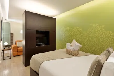 a hotel room with a bed and a television at Ola Living Portaferrissa in Barcelona