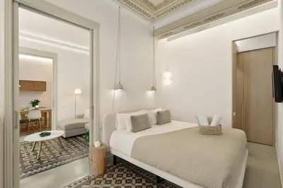 a white bedroom with a bed and a mirror at Ola Living Portaferrissa in Barcelona