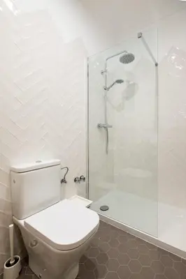 a white bathroom with a shower and a toilet at eg21- MODERNIST AND ELEGANT APARTMENT IN BCN CITY CENTER in Barcelona