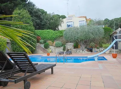 a swimming pool with a slide in a house at Villa Magnolia in Mataró