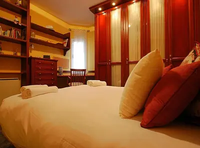 a bedroom with a large white bed with red pillows at Villa Magnolia in Mataró
