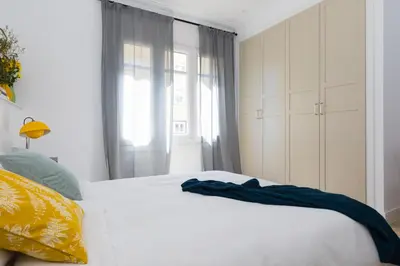 a bedroom with a white bed and a window at Casa Cosi - Eixample 3 in Barcelona