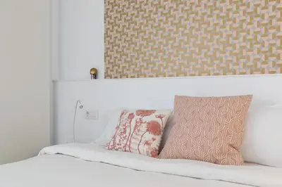 a bed with two pillows on top of it at Casa Cosi - Eixample 3 in Barcelona