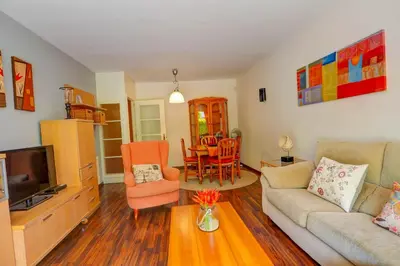 a living room with a couch and a tv at Megan Apartment by Hello Homes Sitges in Sitges