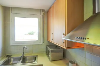 a kitchen with a sink and a window at Portman Duplex by Hello Homes Sitges in Sitges