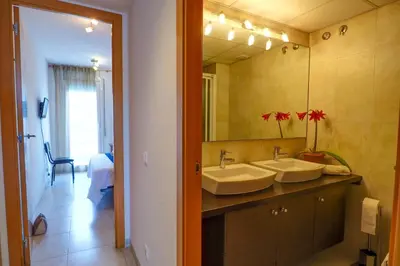 a bathroom with two sinks and a large mirror at Portman Duplex by Hello Homes Sitges in Sitges