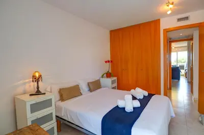 a bedroom with a bed with two towels on it at Portman Duplex by Hello Homes Sitges in Sitges