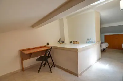 a kitchen with a counter with a chair and a desk at Portman Duplex by Hello Homes Sitges in Sitges
