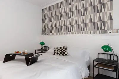 a bedroom with two beds and a table with lamps at Casa Cosi - Eixample 4 in Barcelona