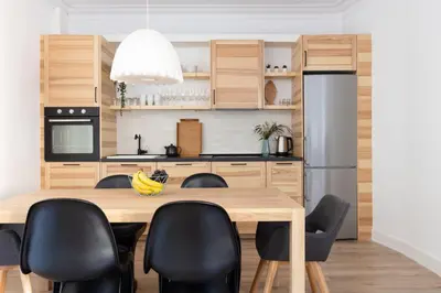 a kitchen with a wooden table and black chairs at Casa Cosi - Eixample 5 in Barcelona