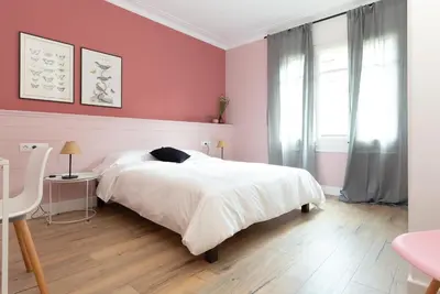 a bedroom with a white bed and a pink wall at Casa Cosi - Eixample 5 in Barcelona