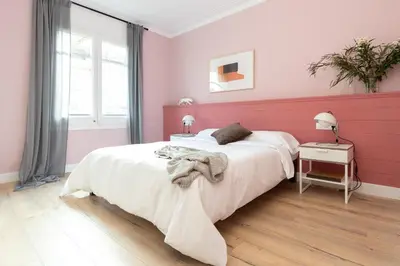 a bedroom with a large bed with pink walls at Casa Cosi - Eixample 5 in Barcelona